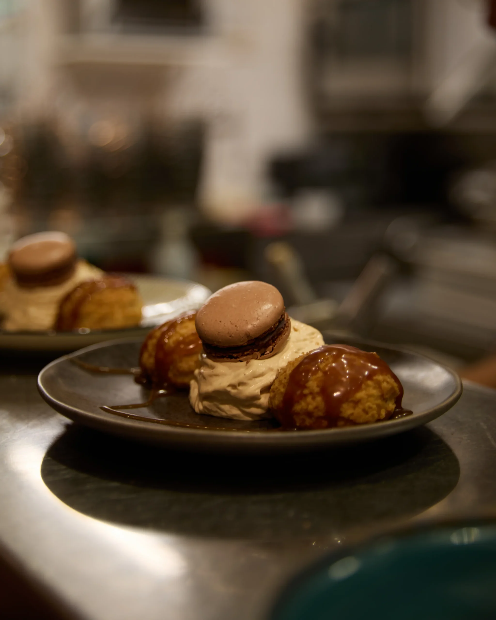 Assiette de dessert composée de choux et macaron maison servie au restaurant Le Trinquet à Soorts-Hossegor, présentation élégante et gourmande