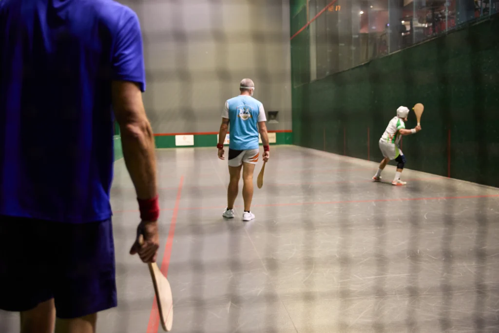 Joueurs de pala en action dans le trinquet vitré du restaurant Le Trinquet à Soorts-Hossegor, ambiance sportive et conviviale